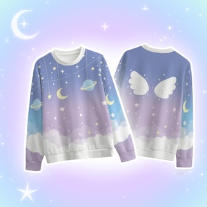 May include: A long-sleeve crewneck sweatshirt featuring a celestial print with a gradient of blue, purple, and white. The front displays planets, crescent moons, and stars, while the back features a pair of white angel wings centered.