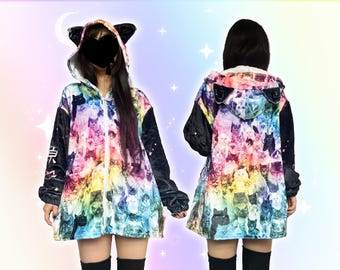 May include: A colourful hooded jacket with a cat pattern. The jacket displays a vibrant array of cats. It has black sleeves and a hood with cat ears. The jacket is zipped up and worn by a person.