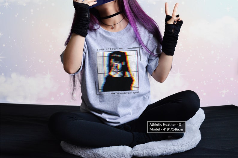 K&ouml;nnte beinhalten: Graues T-Shirt mit einem Grafikdruck einer Frau mit Glitch-Effekt. Der Text auf dem Shirt lautet "もう一度、やり直せない Can we start over again?" Das Model ist 1,46 m gro&szlig; und tr&auml;gt Gr&ouml;&szlig;e S.