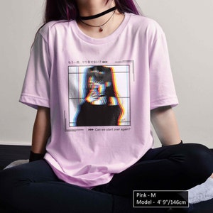 K&ouml;nnte beinhalten: Pinkes T-Shirt mit einem Grafikdruck einer Frau mit Glitch-Effekt und dem Text "もう一度、やり直せない? Can we start over again?" auf der Vorderseite. Das Model ist 146 cm gro&szlig; und tr&auml;gt Gr&ouml;&szlig;e M.