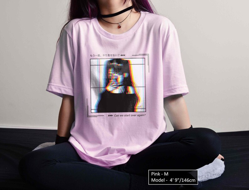 K&ouml;nnte beinhalten: Pinkes T-Shirt mit einem Grafikdruck einer Frau mit Glitch-Effekt und dem Text "もう一度、やり直せない? Can we start over again?" auf der Vorderseite. Das Model ist 146 cm gro&szlig; und tr&auml;gt Gr&ouml;&szlig;e M.