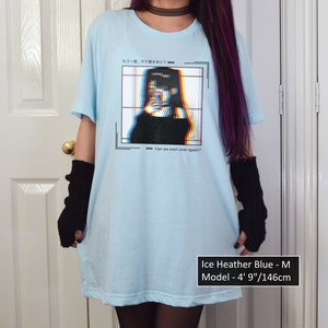 K&ouml;nnte beinhalten: Hellblaues T-Shirt mit einem Grafikdruck einer Frau in einem schwarzen Shirt mit Glitch-Effekt. Der Text auf dem Shirt lautet "もう一度、やり直せない?" und "Can we start over again?" Das Model ist 146 cm gro&szlig;.