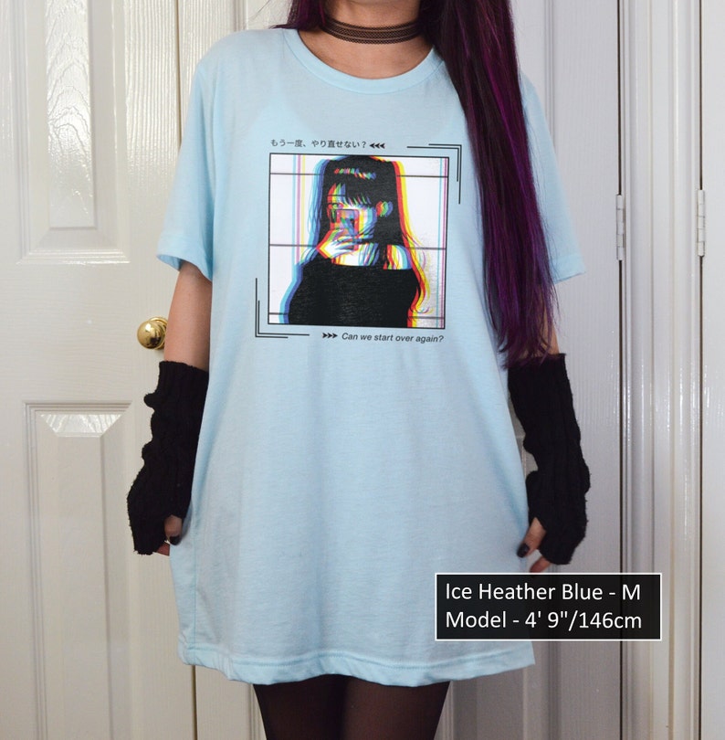 K&ouml;nnte beinhalten: Hellblaues T-Shirt mit einem Grafikdruck einer Frau in einem schwarzen Shirt mit Glitch-Effekt. Der Text auf dem Shirt lautet "もう一度、やり直せない?" und "Can we start over again?" Das Model ist 146 cm gro&szlig;.