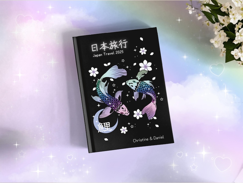 May include: Black journal with a Japanese design featuring two koi fish, cherry blossoms, and the text "日本旅行 Japan Travel 2025" and "Christine & Daniel".