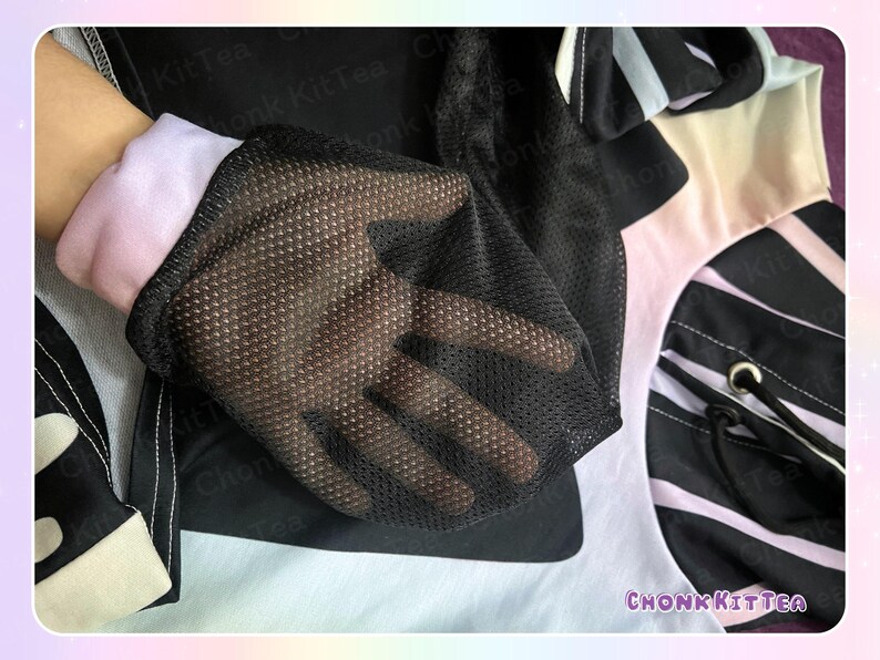 May include: Close-up of a black mesh glove over a light pink and white sleeve. The glove is part of a black and white patterned garment. The text "CHONKKITTEA" is visible in the lower right corner.