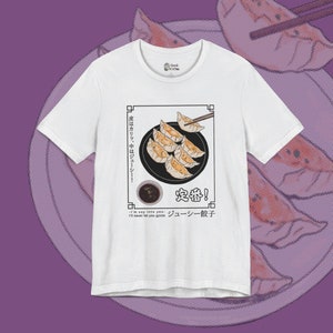 May include: White t-shirt with a graphic of a plate of dumplings, chopsticks, and a small bowl of dipping sauce. The text on the shirt reads "皮はカリッ、中はジューシー!" "定番!" "ジューシー餃子" and "I'm say into you I'll never let you gyoza".