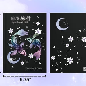 May include: A black journal with a Japanese design featuring two koi fish, cherry blossoms, and a crescent moon. The text "日本旅行" (Japan Travel) and "Japan Travel 2025" are printed on the front cover. The journal measures 8 inches by 5.75 inches.