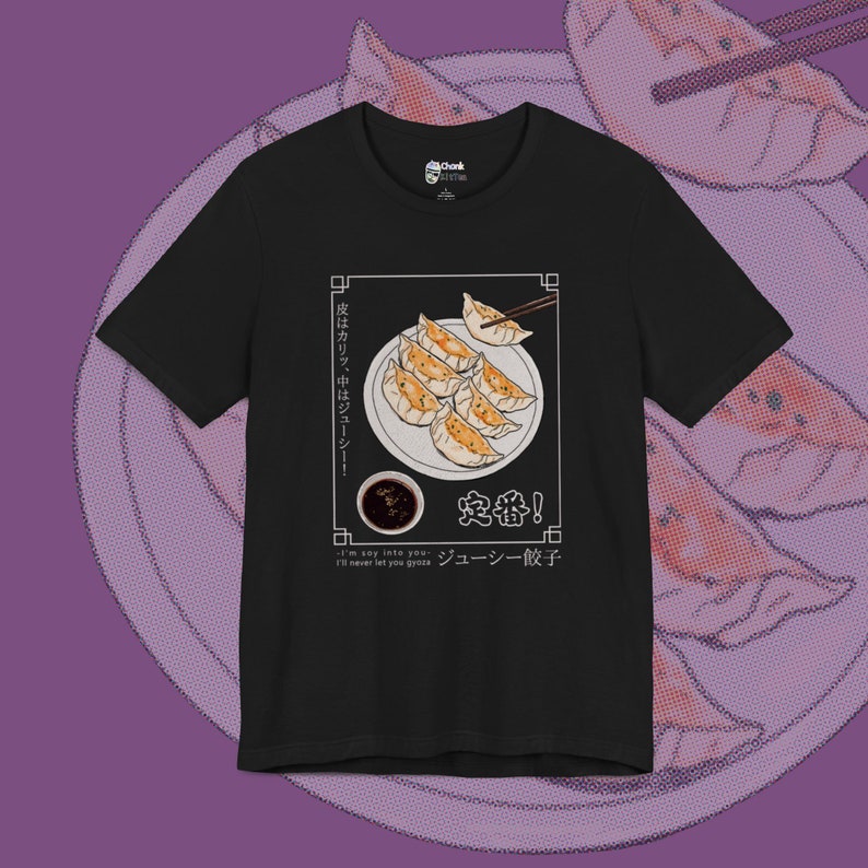 May include: Black t-shirt with a graphic of a plate of dumplings, chopsticks, and a small bowl of dipping sauce. The text "皮はカリッ、中はジューシー!" (Pi wa karri, naka wa juushi!) and "定番!" (Teban!) are written in Japanese. The text "ジューシー餃子" (Juushi Gyoza) and "I'm say inte you I'll never let you groza" are written in English.