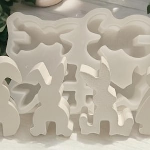 Könnte beinhalten: Ein Set aus weißen Silikonformen in Form von Hasen. Die Formen sind für die Herstellung von Bastelarbeiten oder Dekorationen gedacht.