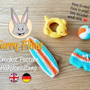 Puede incluir: Patrón de crochet para un lindo conejito, una tabla de surf, un bañador, una pelota de playa y un anillo de pato amarillo. El patrón está disponible en inglés y alemán. "Furry Finn Crochet Pattern Häkelanleitung"