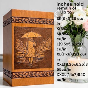 Artistic wooden urn box for human ashes with detailed engraving of a woman walking through a rainy city street under an umbrella. The handcrafted cremation urn includes elegant carved leaf border accents and a polished wood surface, creating a dignified memorial keepsake and tribute for loved ones.