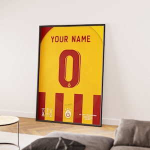May include: A framed poster with a yellow and red design. The poster features a large red number "0" and the text "YOUR NAME". The poster also includes a red and yellow striped pattern and a small logo with a star and the letter "G".
