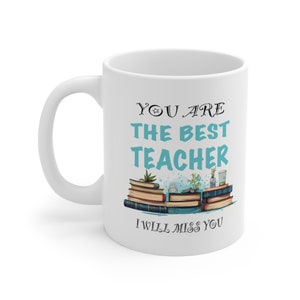 Op de afbeelding: Witte keramische koffiemok met een blauw en zwart ontwerp. De mok heeft de tekst "You are the best teacher I will miss you". Het ontwerp toont een stapel boeken met planten erop.