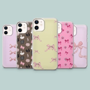 Op de afbeelding: Vijf verschillende telefoonhoesjes met verschillende ontwerpen. De hoesjes zijn transparant en laten een roze en wit strikmotief, een zwart en wit zwanenmotief, een roze hartmotief en een roze strikmotief zien.