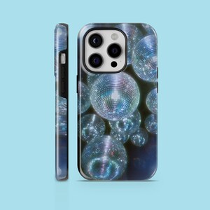 May include: A black phone case with a design of silver disco balls on a dark blue background.