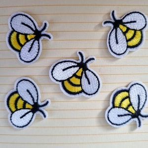 May include: Five embroidered iron-on patches of yellow and white bumblebees. The bees have black eyes and antennae.