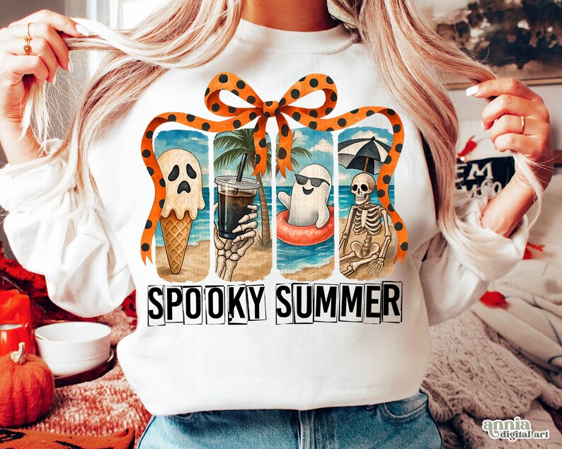 May include: White long-sleeved sweatshirt with a colorful graphic of spooky summer scenes. The design includes a ghost ice cream cone, a skeleton holding a drink, and the words "SPOOKY SUMMER" in black block letters.
