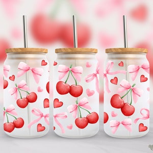 May include: Three clear glass tumblers with lids and straws, featuring a pink and red cherry and bow pattern.