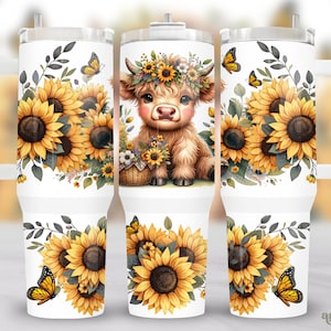 May include: White tumbler featuring a brown and white Highland cow with a floral crown, surrounded by sunflowers and butterflies. The tumbler has a straw and a handle.