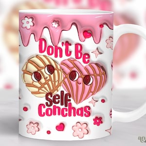 Op de afbeelding: Een witte keramische mok met een roze en witte druipende glazuur. De mok heeft een cartoon afbeelding van twee concha gebakjes met gezichten, en de tekst "Don't Be Self Conchas".