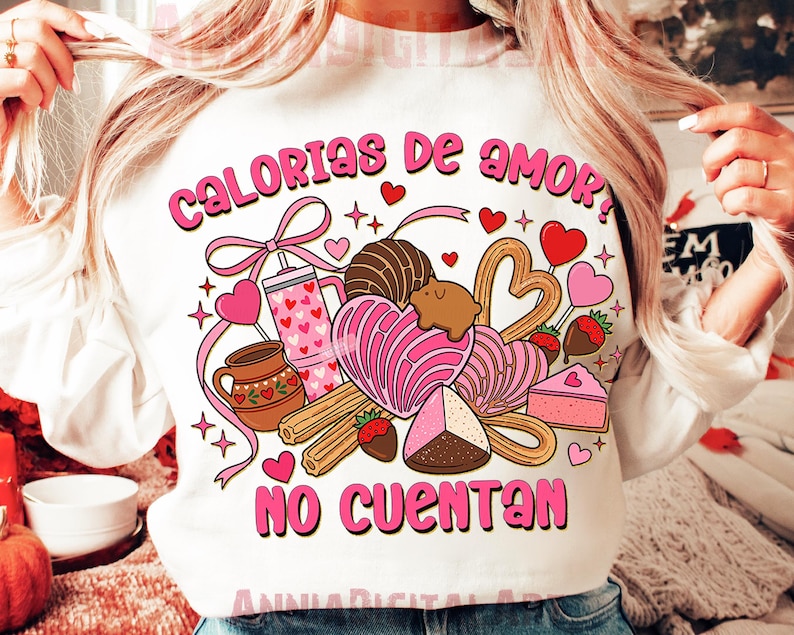 May include: White sweatshirt with a colorful graphic design featuring the text "Calorias de amor? No cuentan." The design includes hearts, sweets, and a pink bow. The sweatshirt is a crew neck style.