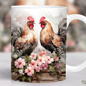May include: White ceramic mug with a watercolor design of two roosters with red combs and wattles, surrounded by pink flowers. The roosters are standing on a wooden fence.
