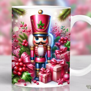 May include: White ceramic mug featuring a festive design with a nutcracker soldier, surrounded by pink gift boxes, holly, and berries. The nutcracker wears a red hat and uniform. The mug has a white handle and the words "annia digital art" are printed on the bottom right.