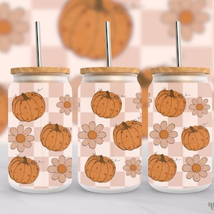 May include: Three glass tumblers with a checkered pattern and a design of orange pumpkins and white flowers. The tumblers have wooden lids and metal straws.