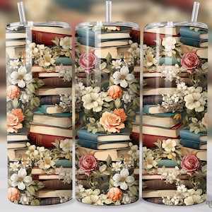 May include: A set of three stainless steel tumblers with a floral and book design. The tumblers feature a stack of vintage books with floral accents in shades of pink, white, and yellow.