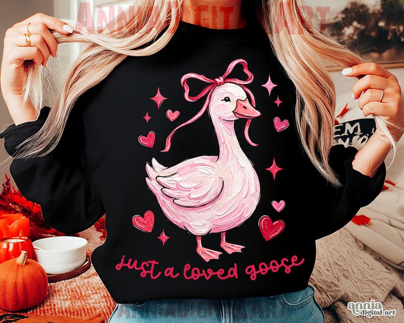 Pu&ograve; includere: Felpa nera con un disegno di un'oca rosa, completa di fiocco, cuori e stelle. La frase "just a loved goose" &egrave; scritta in rosa. Lo stile generale &egrave; stravagante e romantico, perfetto per l'abbigliamento casual.
