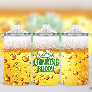 Puede incluir: Tres vasos de plástico transparente con tapas y asas. Los vasos están llenos de un líquido amarillo que se asemeja a la cerveza. El vaso del medio tiene el texto "Daddy's Drinking Buddy" en letras verdes.