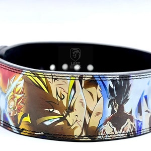 Puede incluir: Un cintur&oacute;n de levantamiento de pesas negro con un estampado de anime colorido con personajes de Dragon Ball Z. El cintur&oacute;n tiene una correa de cuero negro con costuras blancas y una hebilla plateada. El estampado presenta a Goku, Vegeta y otros personajes de la serie de anime.