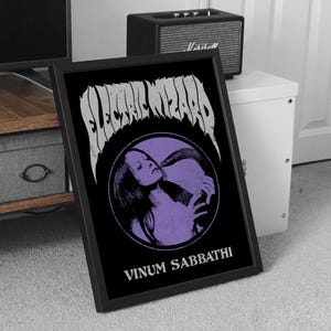Puede incluir: Impresión enmarcada en blanco y negro con una ilustración morada de una mujer con el pelo largo. El texto "Electric Wizard" y "Vinum Sabbathi" está impreso en blanco en la impresión.