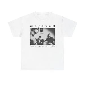 May include: White t-shirt featuring a black and white image of a band with the text "mojave 3" above the image and "love songs on the radio" below. The shirt is a classic crew neck style.