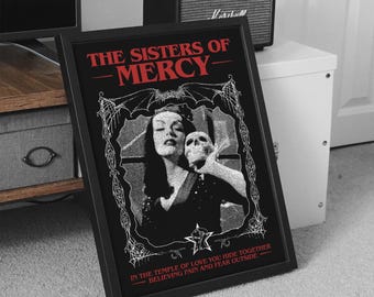 May include: Black and white framed print with a gothic design featuring a woman holding a skull. The text "THE SISTERS OF MERCY" is in red at the top of the print. The text "IN THE TEMPLE OF LOVE YOU HIDE TOGETHER BELIEVING PAIN AND FEAR OUTSIDE" is in red at the bottom of the print.