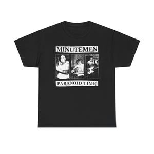May include: Black t-shirt with a white graphic of a band called "Minutemen" and the text "Paranoid Time". The graphic features three people playing instruments.