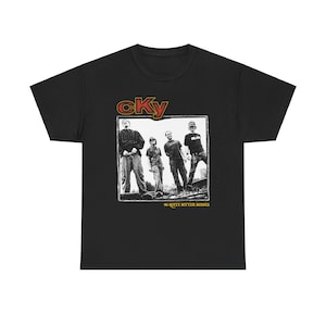 May include: Black t-shirt featuring a grayscale image of four people and the band name "cKy" in red and gold. Below the image is the text "96 Quite Bitter Beings". The shirt is made of a soft material.