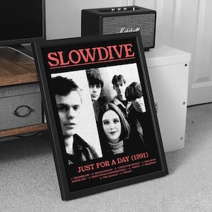 Puede incluir: Póster enmarcado en negro con la banda Slowdive, con el texto "SLOWDIVE" en rojo. El póster incluye el título del álbum "JUST FOR A DAY (1991)" y una lista de títulos de canciones. La imagen es en blanco y negro.