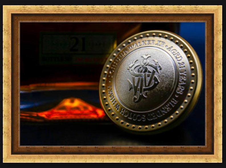 May include: A gold-colored round metal bottle stopper with the words "Johnnie Walker Aged 21 Years" and "Scotch Whisky" engraved on it.