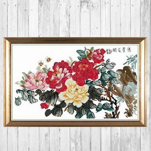 May include: A framed cross-stitch embroidery featuring a bouquet of pink, red, and yellow peonies with green leaves and a bird on a branch. The Chinese characters "锦繡江山" are embroidered in the top right corner.