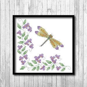 May include: Cross stitch pattern featuring a yellow dragonfly with purple accents and a border of purple flowers and green leaves.