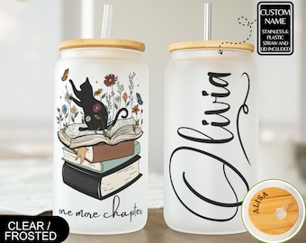 May include: Two frosted glass tumblers with bamboo lids and straws. One tumbler features a black cat sitting on a stack of books with flowers and the text "one more chapter". The other tumbler has the name "Olivia" written in cursive. Both tumblers have a bamboo lid with a straw hole.