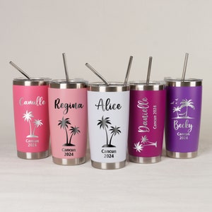 May include: Five stainless steel tumblers in various colors: pink, light pink, white, magenta, and purple. Each tumbler has a silver lid and straw. The tumblers are personalized with names, palm tree graphics, and "Cancun 2024" text.