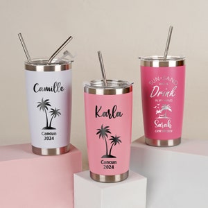 May include: Three stainless steel travel tumblers with lids and straws. One is white with "Camille" and a palm tree graphic, another is pink with "Karla", and the third is pink with "Sun, Sand, and a Drink" and "Sarah" text. All have "Cancun 2024".