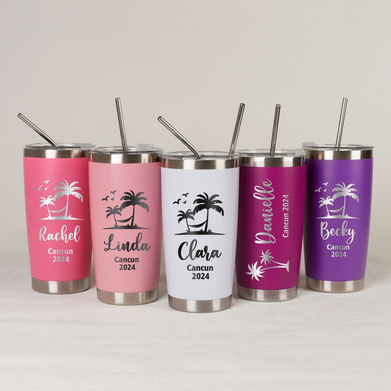 Op de afbeelding: Vijf gepersonaliseerde bekers in roze, wit en paars, elk met een zilveren deksel en rietje. De bekers hebben een tropisch ontwerp met palmbomen, een hangmat en de namen Rachel, Linda, Clara, Danielle en Becky, met "Cancun 2024".