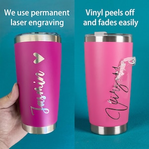 May include: Two pink stainless steel tumblers with lids. The tumbler on the left has a heart and the name "Jasmin" engraved on it. The tumbler on the right has the word "Vinyl" peeling off of it. The text "We use permanent laser engraving" is above the left tumbler. The text "Vinyl peels off and fades easily" is above the right tumbler.