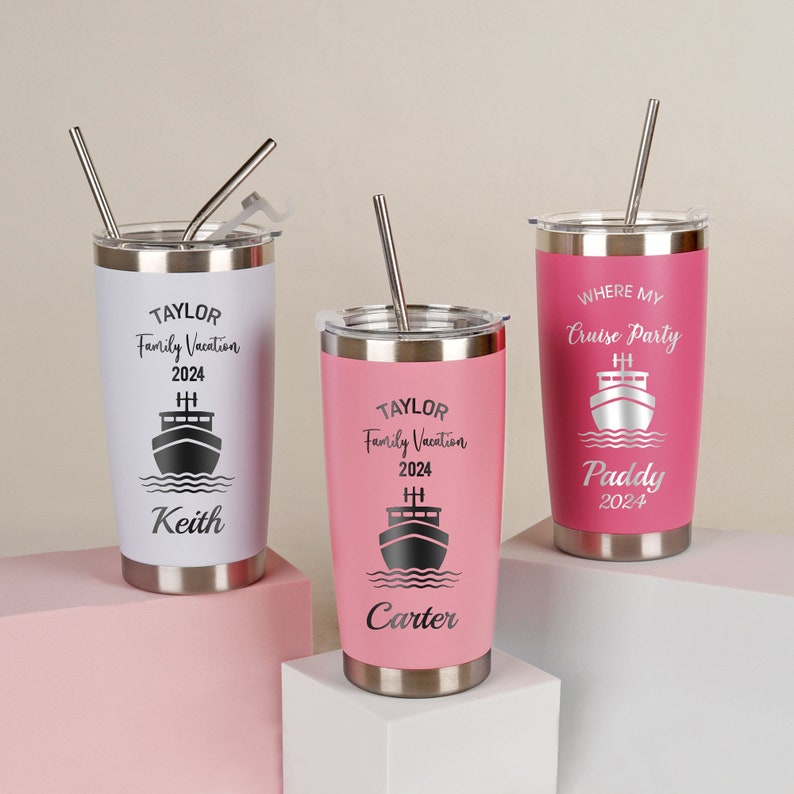 May include: Three personalized stainless steel tumblers with lids and straws. The tumblers are pink and white with a cruise ship design and the text "TAYLOR Family Vacation 2024 Keith", "TAYLOR Family Vacation 2024 Carter", and "WHERE MY Cruise Party Paddy 2024".