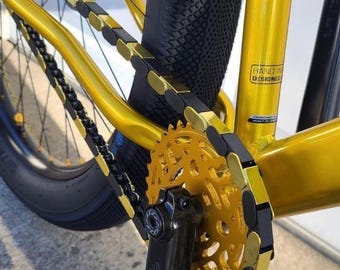 Cubrecadenas de bicicleta negros y dorados - Tapas de cadena a presión - Aptas para bicicletas infantiles, BMX, cruisers y eléctricas - Accesorio para bicicletas