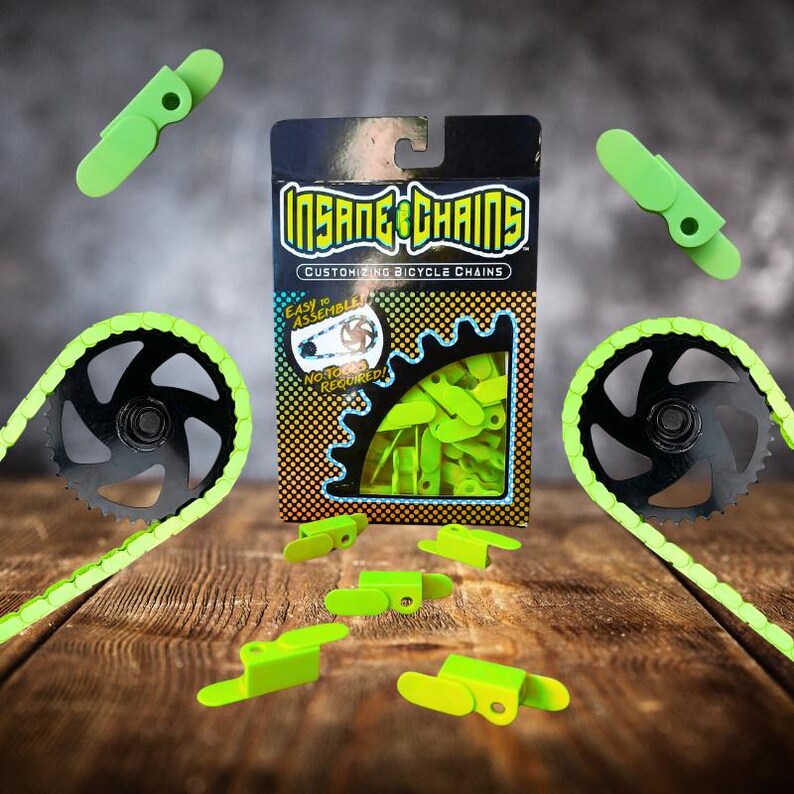 May include: A product shot of a bicycle chain customization kit. The kit includes neon green chain links, a black and green chain, and a black and silver gear. The packaging reads "INSANE CHAINS" and "Customizing Bicycle Chains."