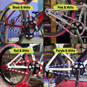 May include: Four BMX bikes with different color schemes. The bikes feature black and white, pink and white, red and white, and purple and white chain guards and tires. Each bike has a different color combination, with the text labels above each bike.